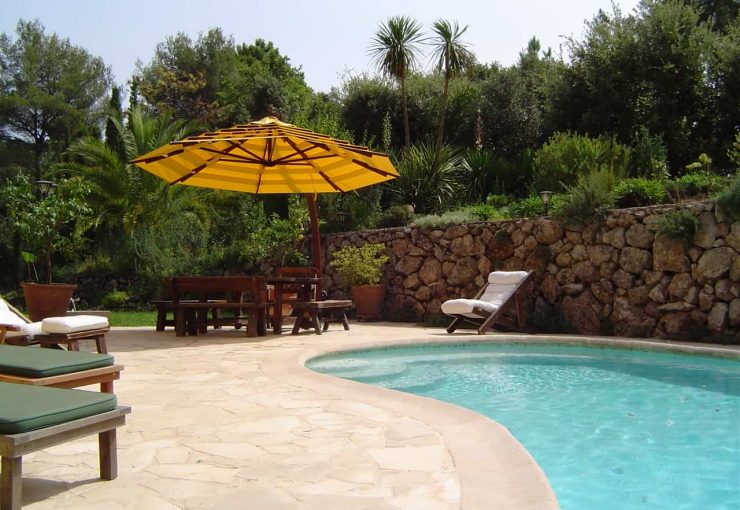 parasol excentré arcobaleno jaune au bord de la piscine